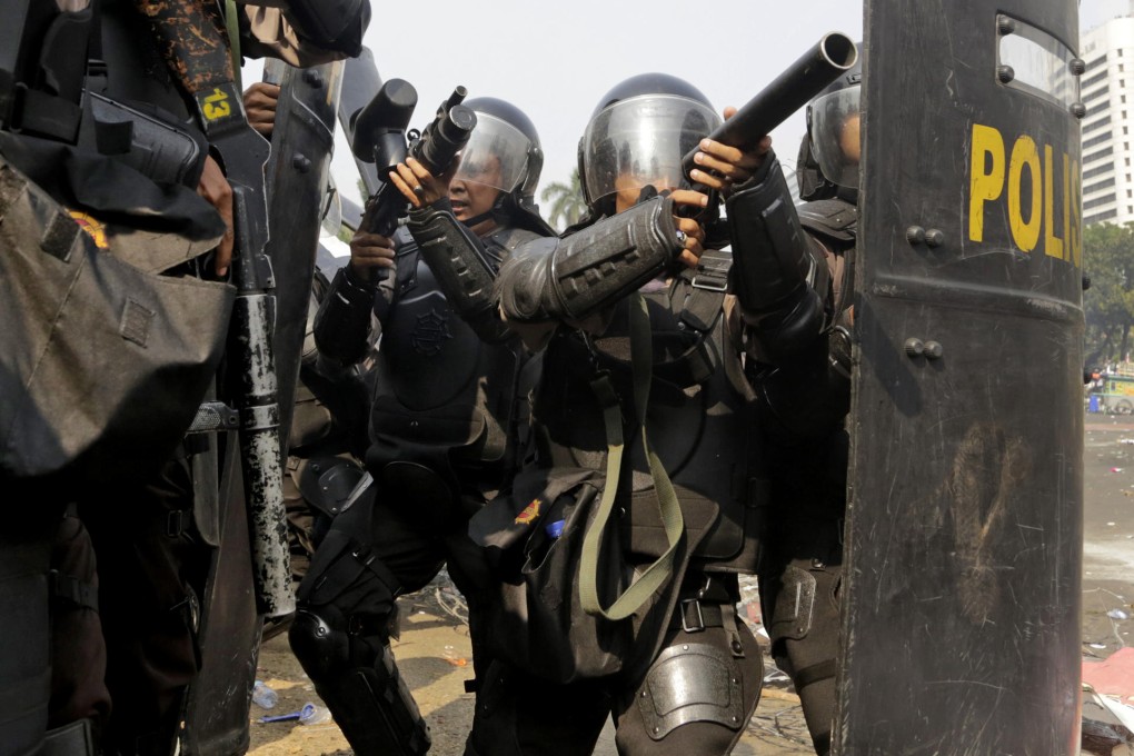 Riot police prepare to fire tear gas at protesters. Photo: AP