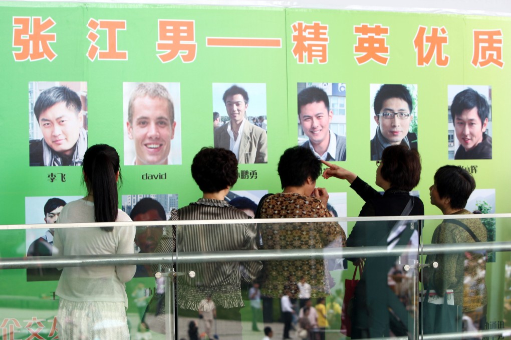 Parents of unmarried young women look at photos of young male singles during a matchmaking event at the Expo Park in Shanghai, China, 26 May 2012. Photo: AFP