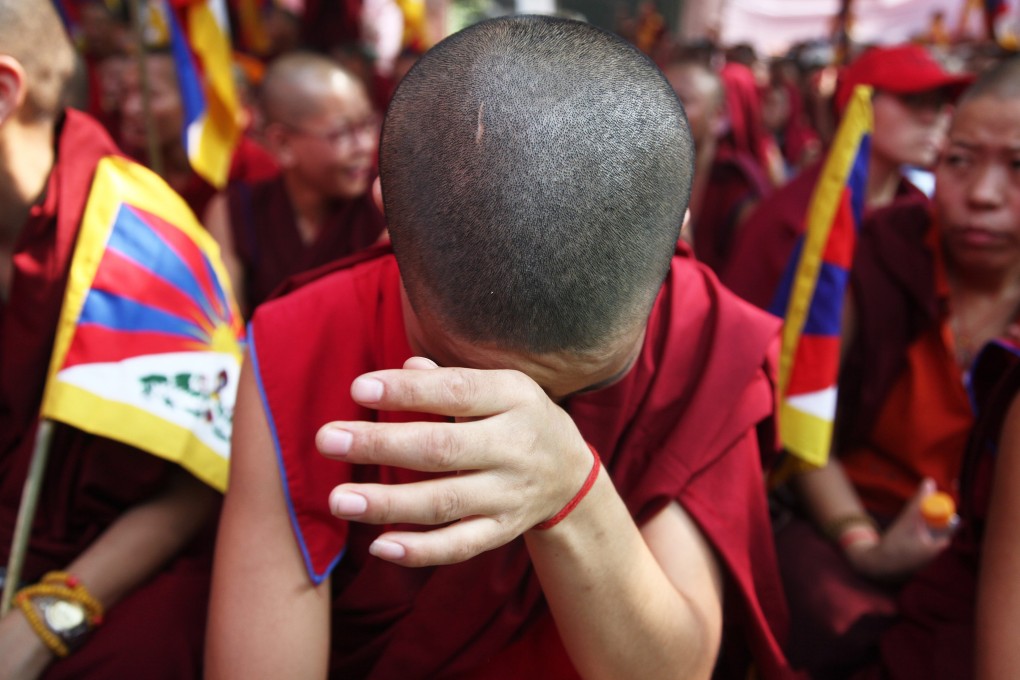 An exiled Tibetan cries as he participates in a protest held in New Delhi, India. Rights groups blame the clashes in Tibet on cultural and religious repression, claims that the Chinese government denies. Photo: EPA