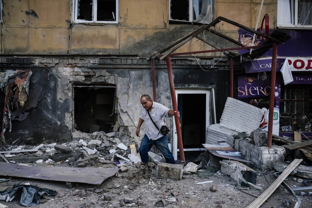 A man leaves a building after shelling in Donetsk. Photo: AFP