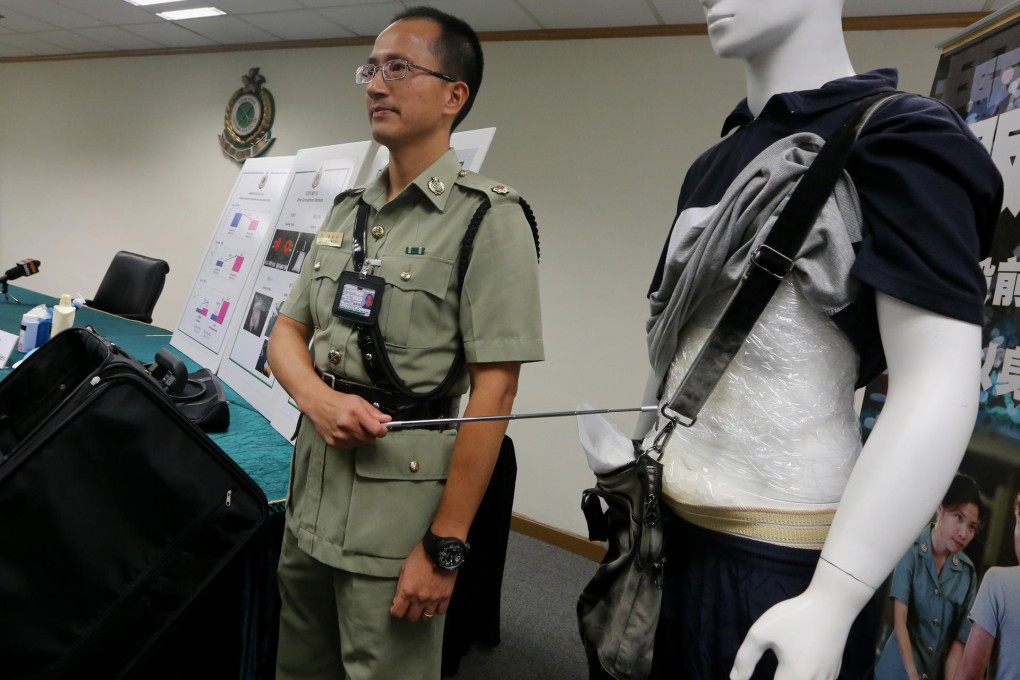 The customs department's Wong Jug-tung shows how smugglers try to conceal the drugs on their bodies. Photo: David Wong
