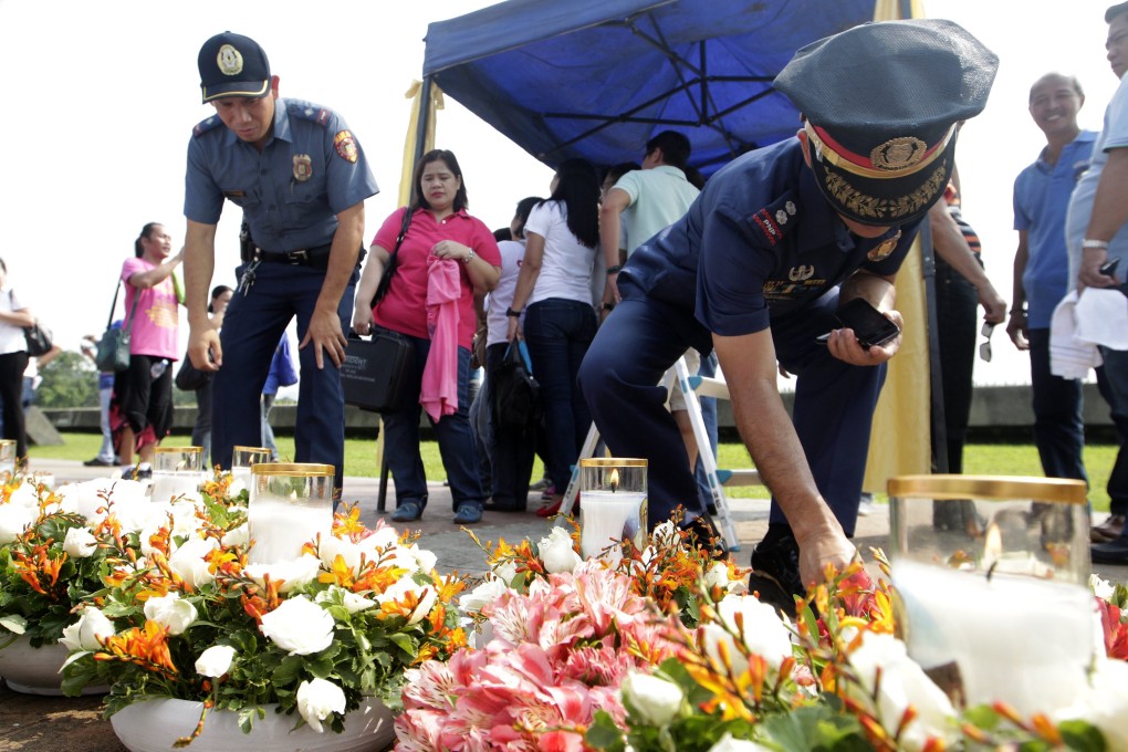 Filipino police officers light candles during the commemoration ceremony in Quirino grandstand, Manila. A disgruntled former cop had hijacked a bus full of Hong Kong tourists in 2010.  Photo: EPA
