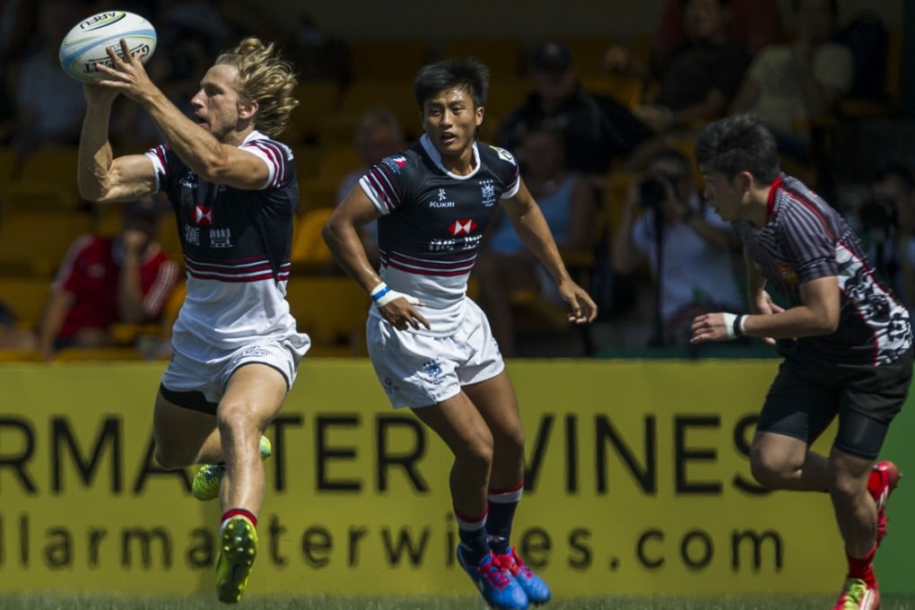 Tom McQueen grabs the ball with Cado Lee in support as Hong Kong defeat Singapore 38-0 in Sunday's Cup quarter-final of the RS Hong Kong Asian Sevens. Photo: Xaume Olleros/Power Sport Images
