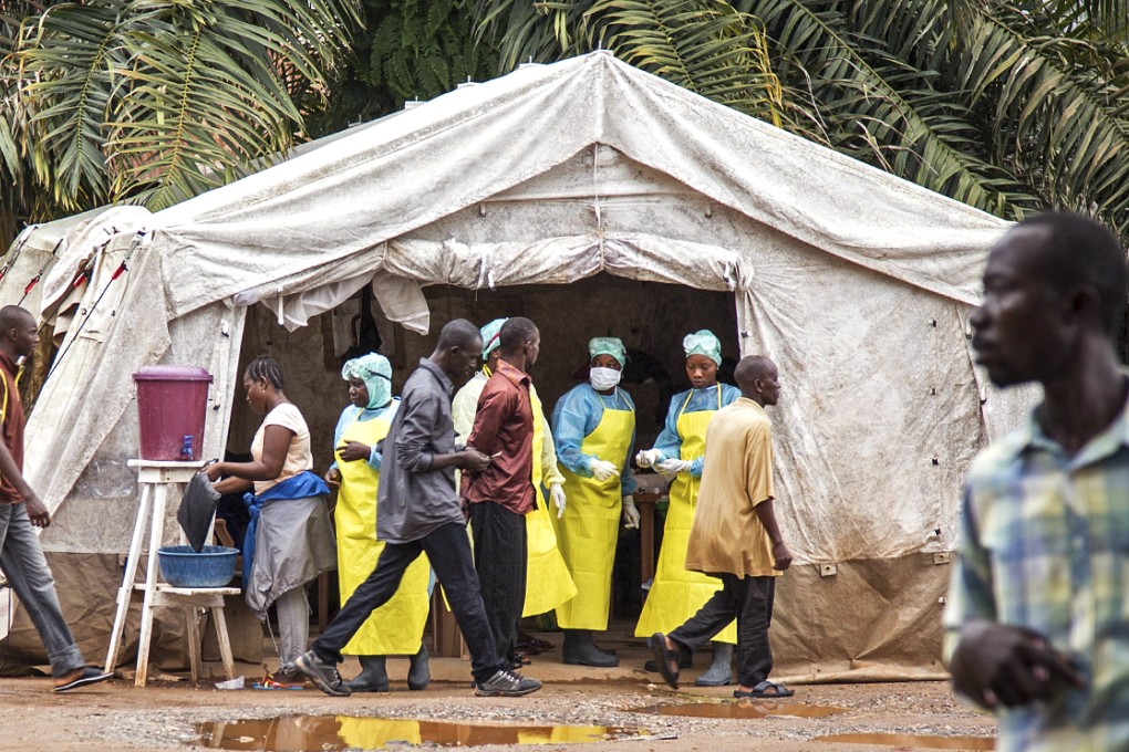 Health workers screen people for the deadly Ebola virus before entering the Kenema Government Hospital in Kenema, Sierra Leone. Photo: AP