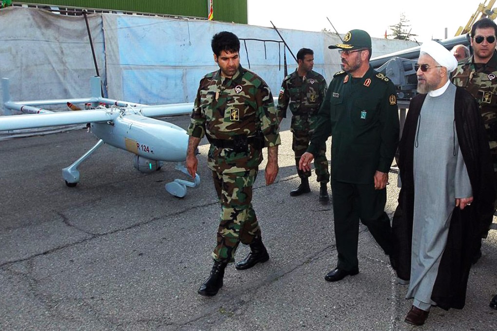 Iranian President Hassan Rowhani passes by an Iranian drone R12. Iran said it shot down an Israeli spy drone that crossed into its airspace near the nuclear facility in Natanz. Photo: EPA
