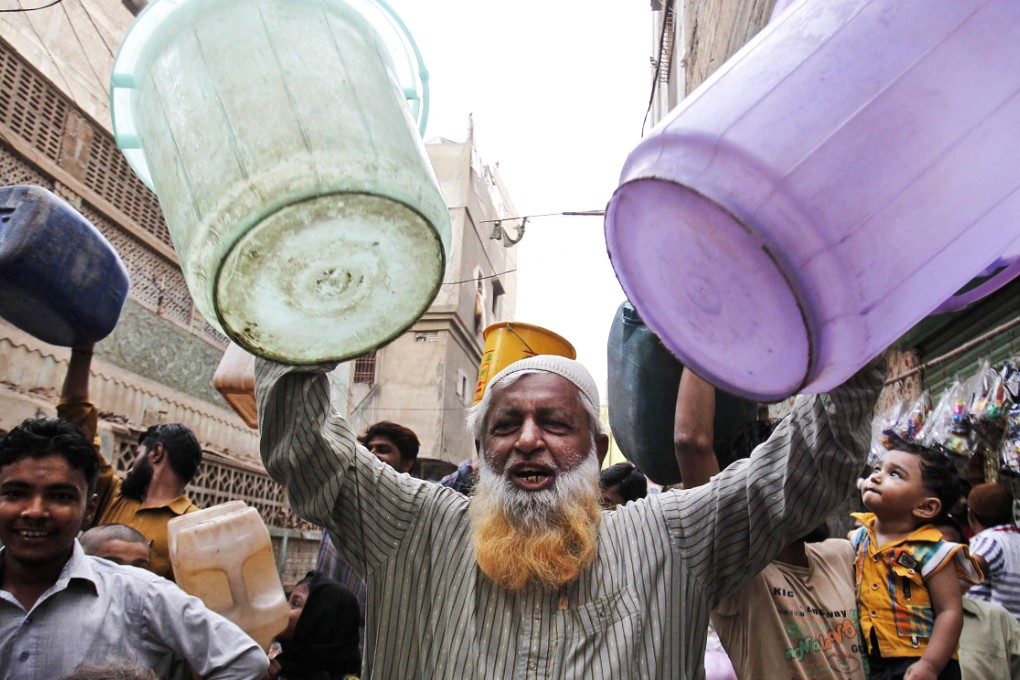 A protester holds empty buckets as people take to the streets over the water shortage in Karachi, a city of 18 million people. Photo: AP