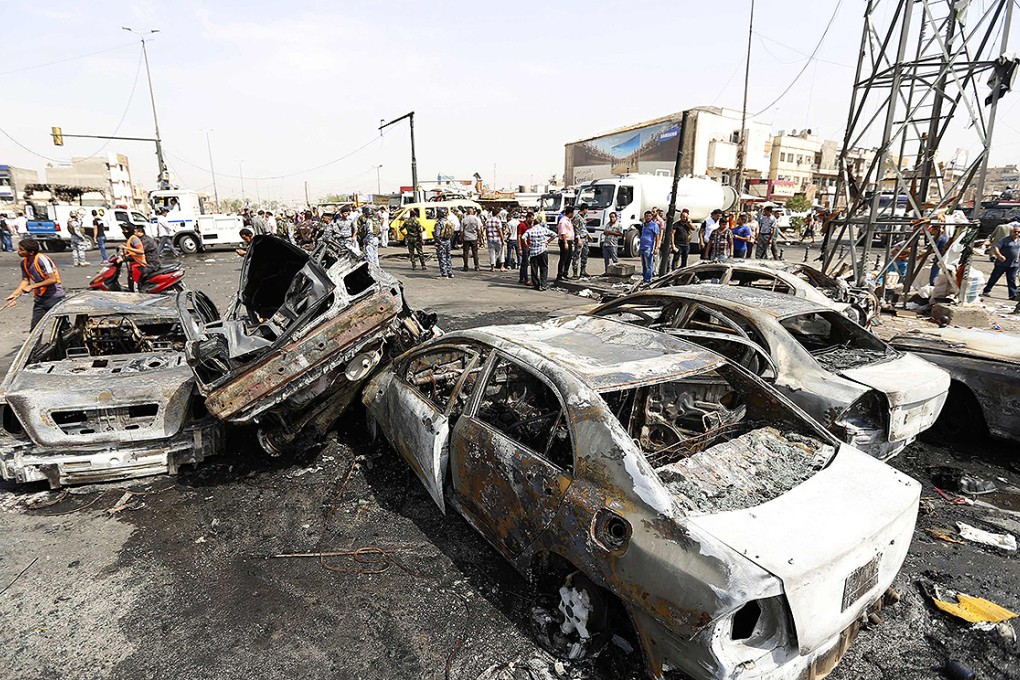 Vehicles destroyed by the car bomb attack sit at a busy intersection in New Baghdad. Photo: Reuters