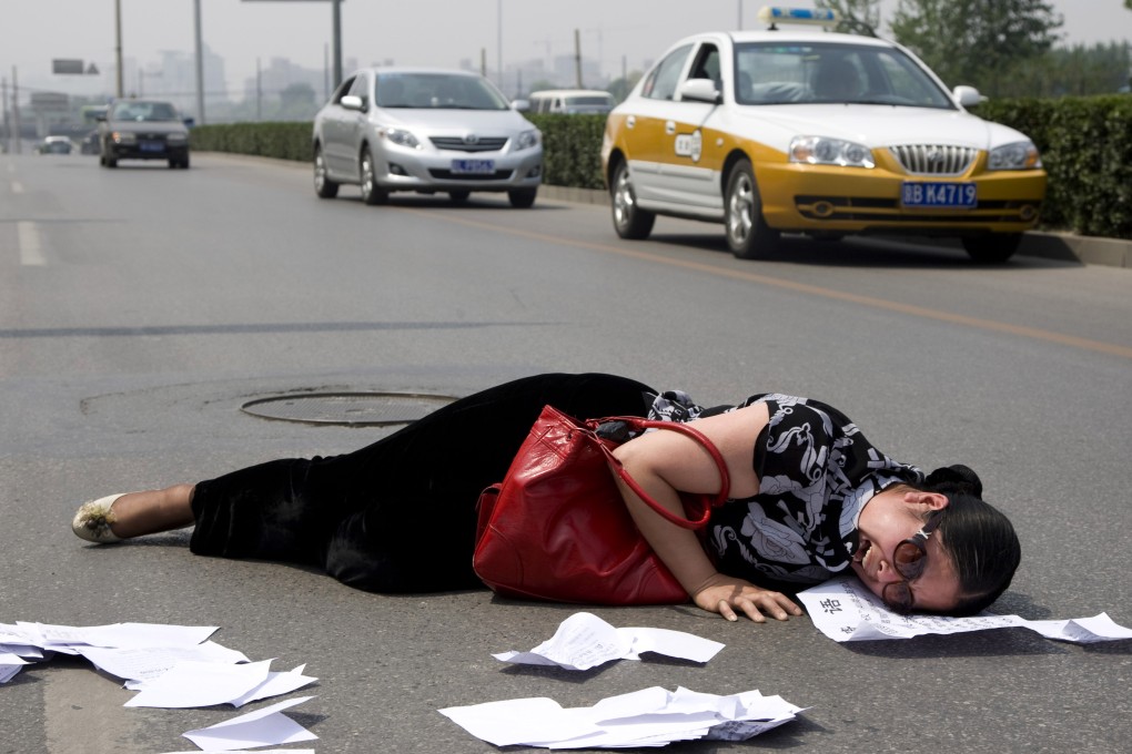 A distraught petitioner in Beijing. Local government officials have been known to forcefully prevent petitioners from lodging a complaint. Photo: AP