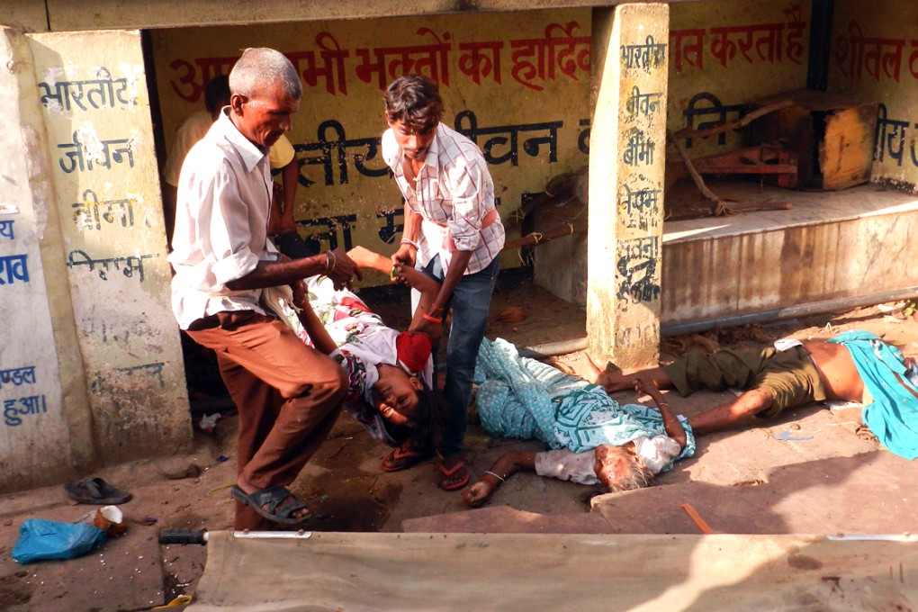 Indian residents move the bodies of devotees killed in a stampede on to a stretcher at the Kamta Nath Temple in Chitrakoot district. Photo: AFP