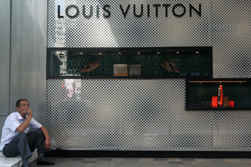 A mainland tourist smokes outside a shop in Canton Road. Smoking in public is one of the habits that sets Hong Kong and the mainland apart. Photo: Sam Tsang