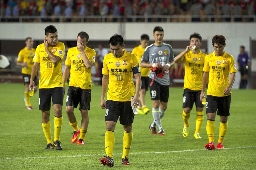 Guangzhou Evergrande captain Zheng Zhi leads his dejected players  off the pitch  at the Tianhe Sport Centre. Photo: AFP
