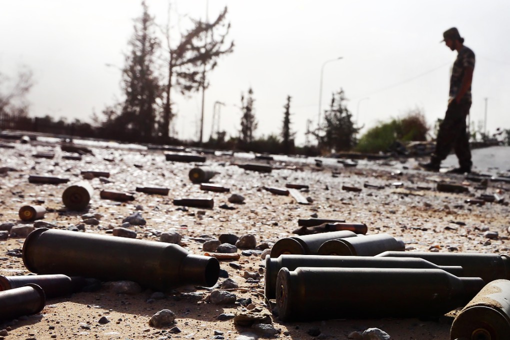 Spent bullet shells litter the ground as a member of the Islamist-linked militia of Misrata walks past following three days of battles in the area of Tripoli's International airport. Photo: AFP