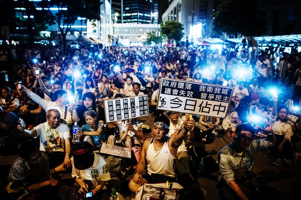 Protesters calling for greater democracy in Hong Kong sit down on a street in Central on July 1. Photo: AFP
