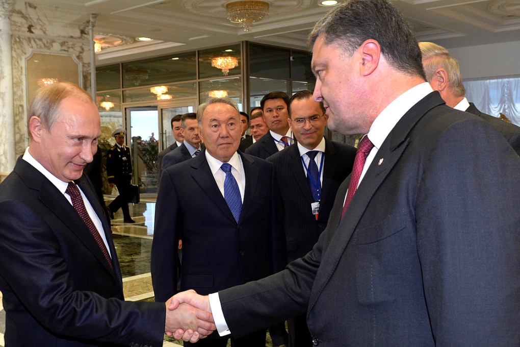 Russia's President Vladimir Putin (left) and Ukraine's President Petro Poroshenko shake hands during a summit in Belarus' capital of Minsk on Tuesday. Photo: AFP