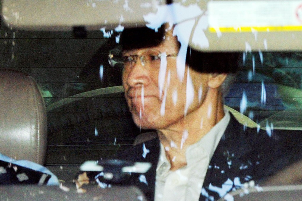 Takuma Sakuragi heads for the Guangzhou Intermediate People's Court in China in a police vehicle on August 27, 2014, to attend the second day of his trial. Photo: Kyodo