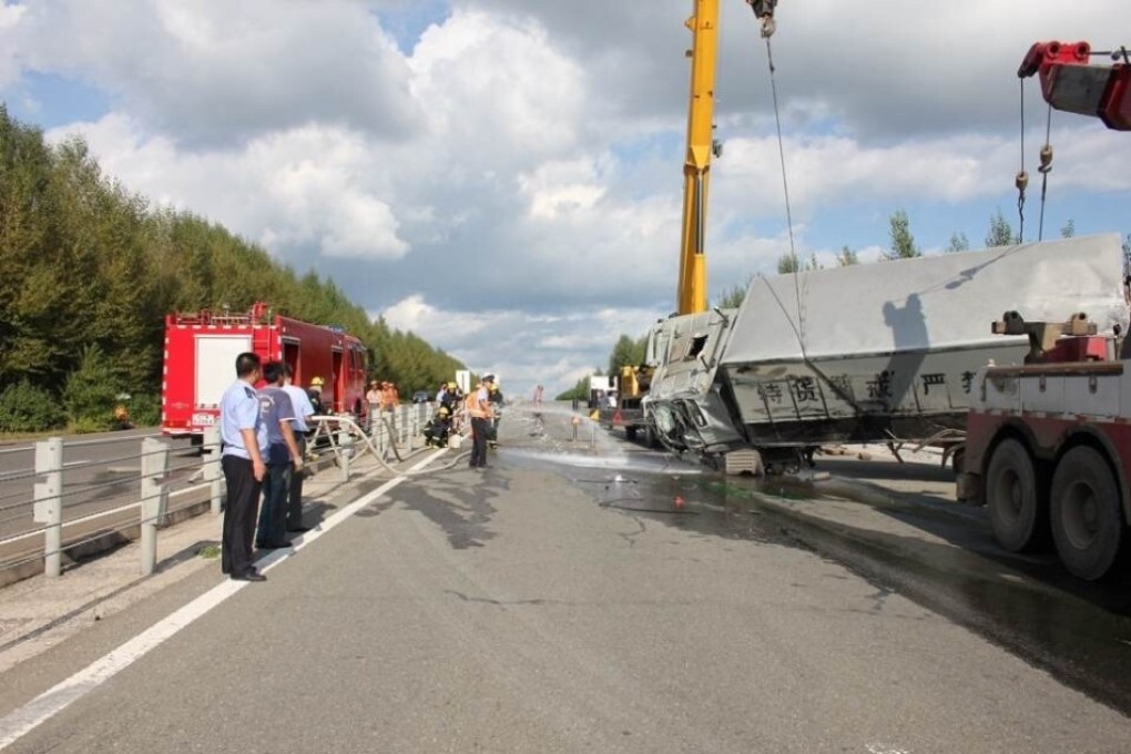 Police officers and emergency workers spray the road with water to prevent leaked fuel from combustion after a truck carrying 1 billion yuan in cash overturned in Heilongjiang province. Photo: SCMP Pictures