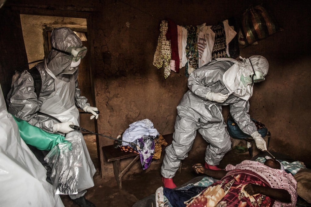 A Red Cross burial team in Sierra Leone takes samples from the body of a woman believed to have died of Ebola. Photo: The Washington Post