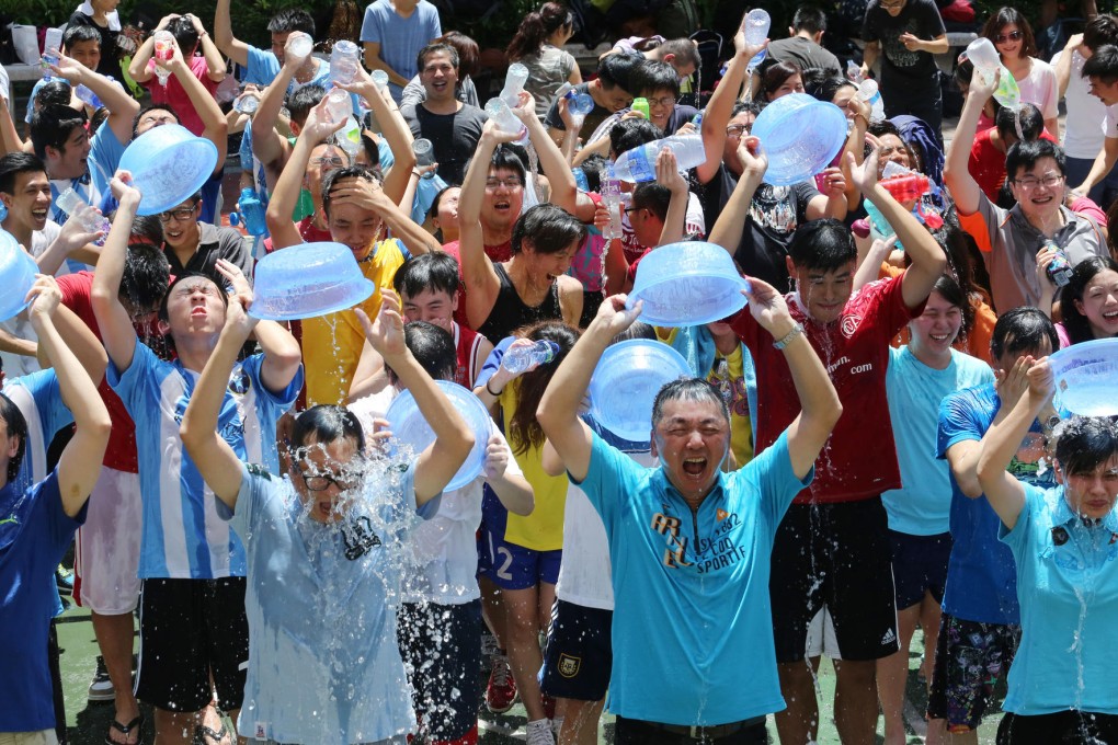 A few of the more than 200 participants in the city’s biggest Ice Bucket Challenge drench themselves with icy water at a park in Jordan yesterday. Photo: Felix Wong