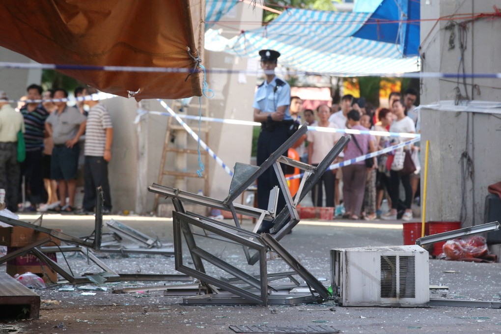 Broken glass and debris, including an air conditioner, littered the street outside the flat where the explosion happened. Photo: K.Y. Cheng