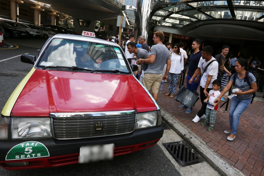 Tourists talk to a taxi driver at the Peak Tram terminus in Garden Road, Central. A typical metered fare to The Peak costs about HK$50. Photo: Jonathan Wong
