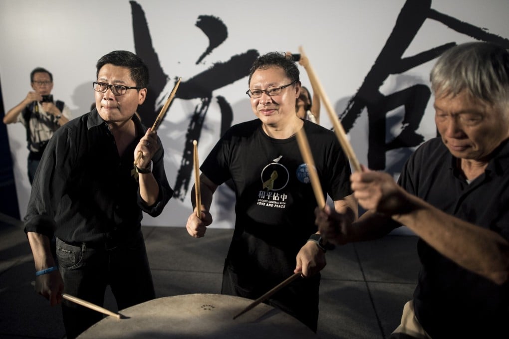 Benny Tai, centre, co-founder of the Occupy Central movement, hits a drum next to other democracy activists at a rally near the Hong Kong government complex on August 31, 2014.  Photo: AFP