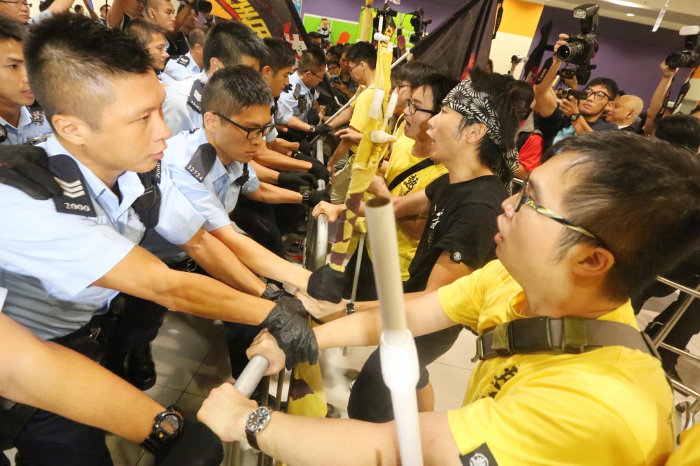 Protesters come face to face with Beijing loyalists and lines of police outside the conference hall yesterday. Photo: Felix Wong