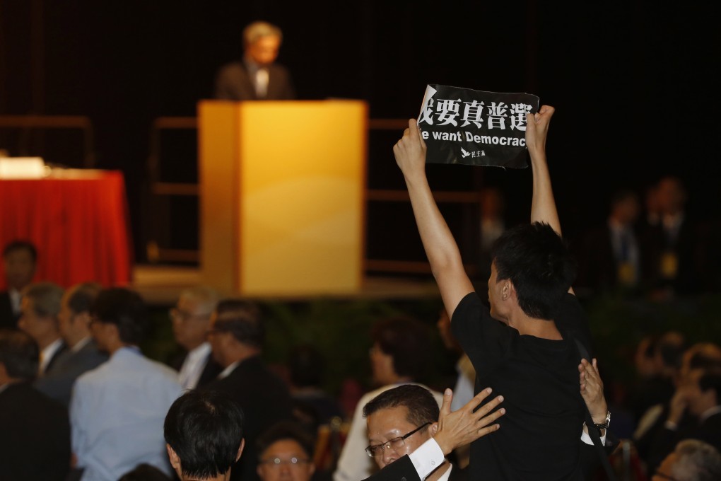 A pro-democracy protester making his feelings known as Li Fei,  deputy general secretary of NPC Standing Committee, speaks in Hong Kong. Photo: AP