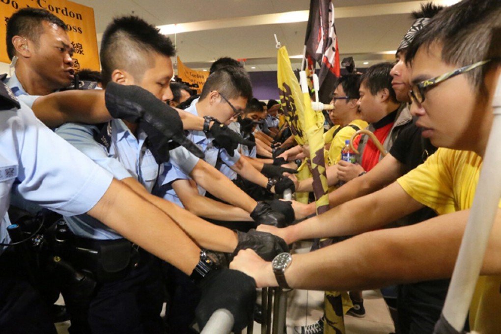 Face off: Police and protesters come face-to-face over a metal barricade before pepper spray is used. Photo: Felix Wong