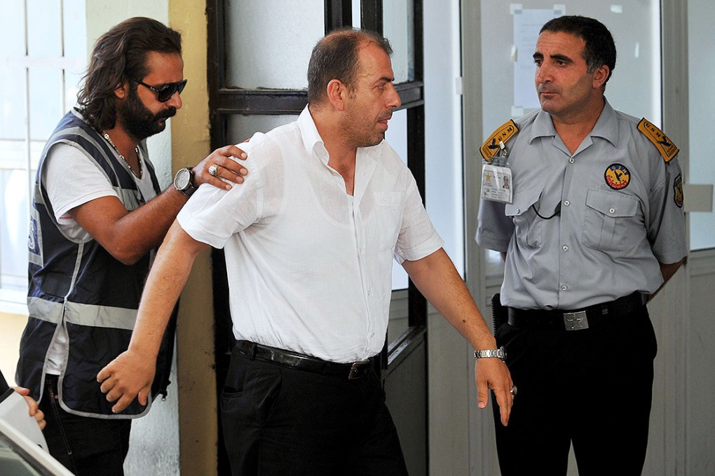 An unidentified police officer is detained in Athens as part of a criminal probe over alleged corruption. Photo: AP