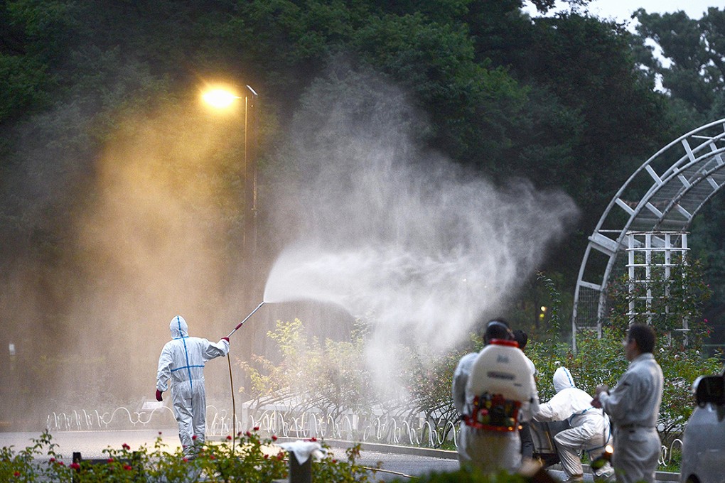 A worker sprays pesticide in Tokyo's Yoyogi Park last week following the discovery of people infected with dengue fever. Photo: AP