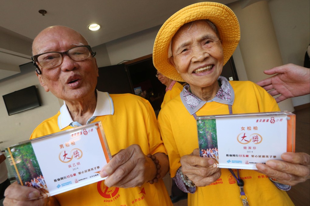 Ng Yuet-ming, 101, and Kan Kit-chun, 98, smile through their hunger yesterday at Sha Tin's Heung Yee Kuk building. Photo: David Wong