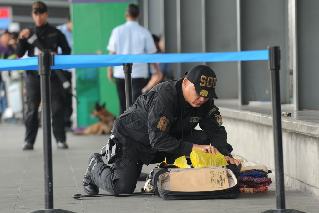 A Philippine police bomb disposal unit member inspects abandoned luggage at Manila's international airport. Photo: AFP