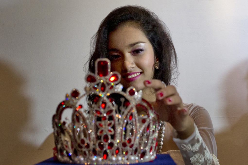 May Myat Noe touches the crown she allegedly ran away with as she holds a press conference to clear her name. Photo: AP