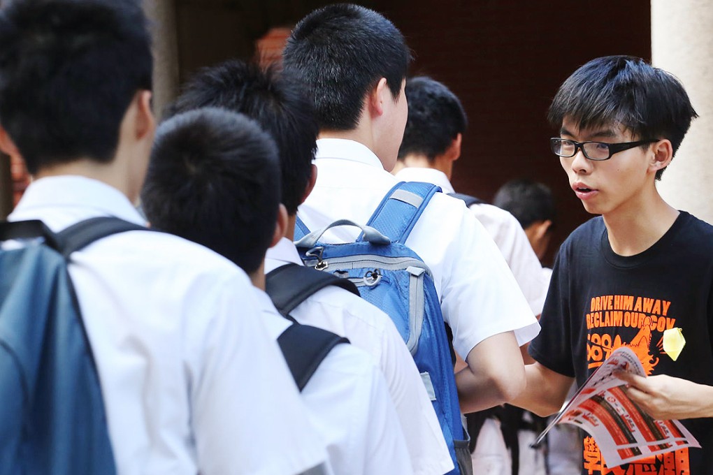 Scholarism founder Joshua Wong hands out fliers to pupils on Bonham Road, Mid-Levels, as they make their way to school. Photo: Felix Wong