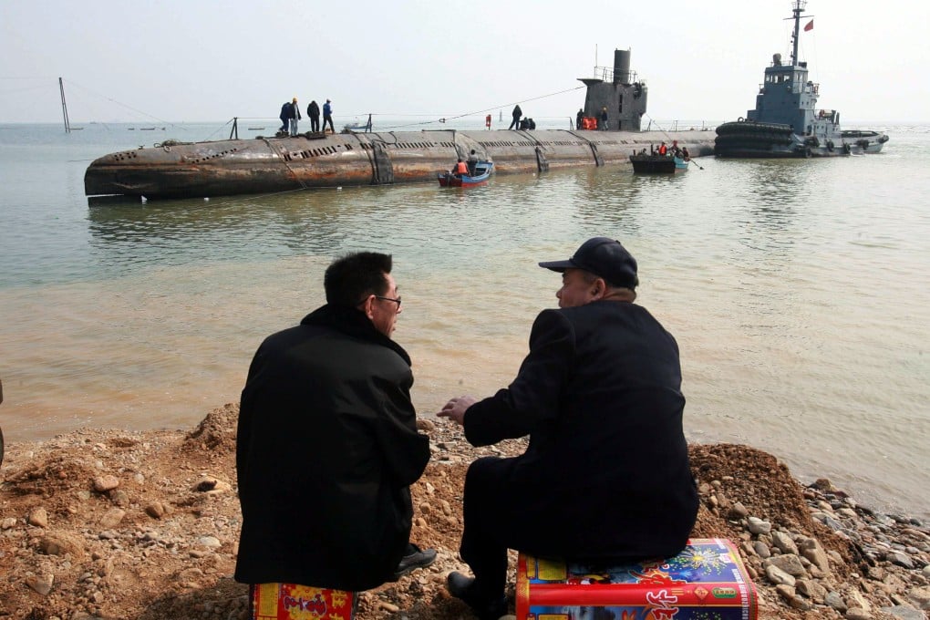 Two residents talk on the seashore while watching a submarine being dragged to its position in northeast China, in this file photo. Photo; AP