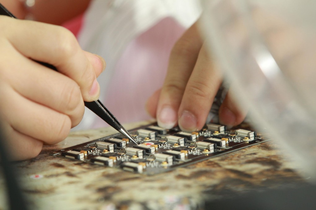 A worker assembles a component at Seeed Studio.