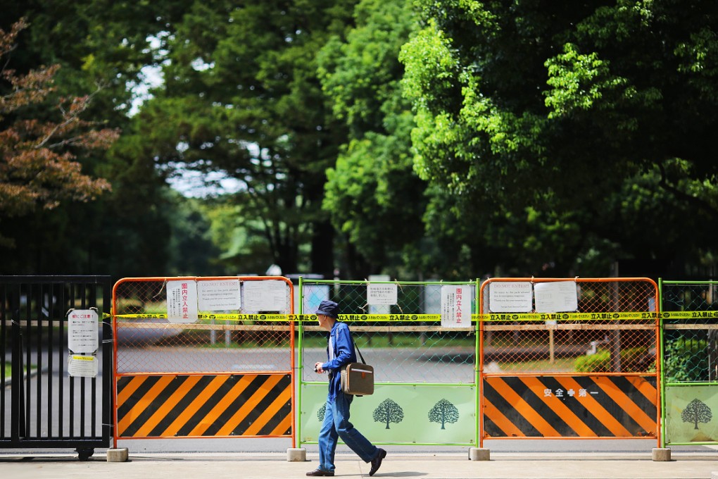 A visitor walks past a closed gate at Yoyogi Park in Tokyo on Friday. Photo: AP