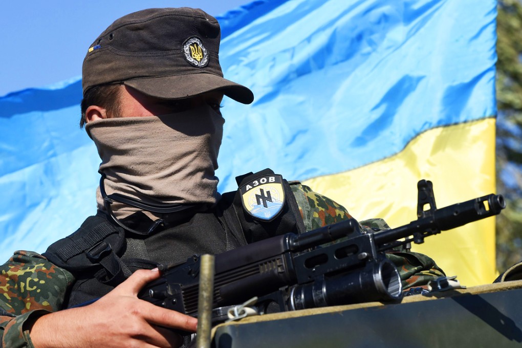 A volunteer of the Ukrainian paramilitary Azov battalion waits on an armoured vehicle, as pro-Russia separatists fire heavy artillery, on the outskirts of the key southeastern port city of Mariupol, on Friday. Photo: AFP