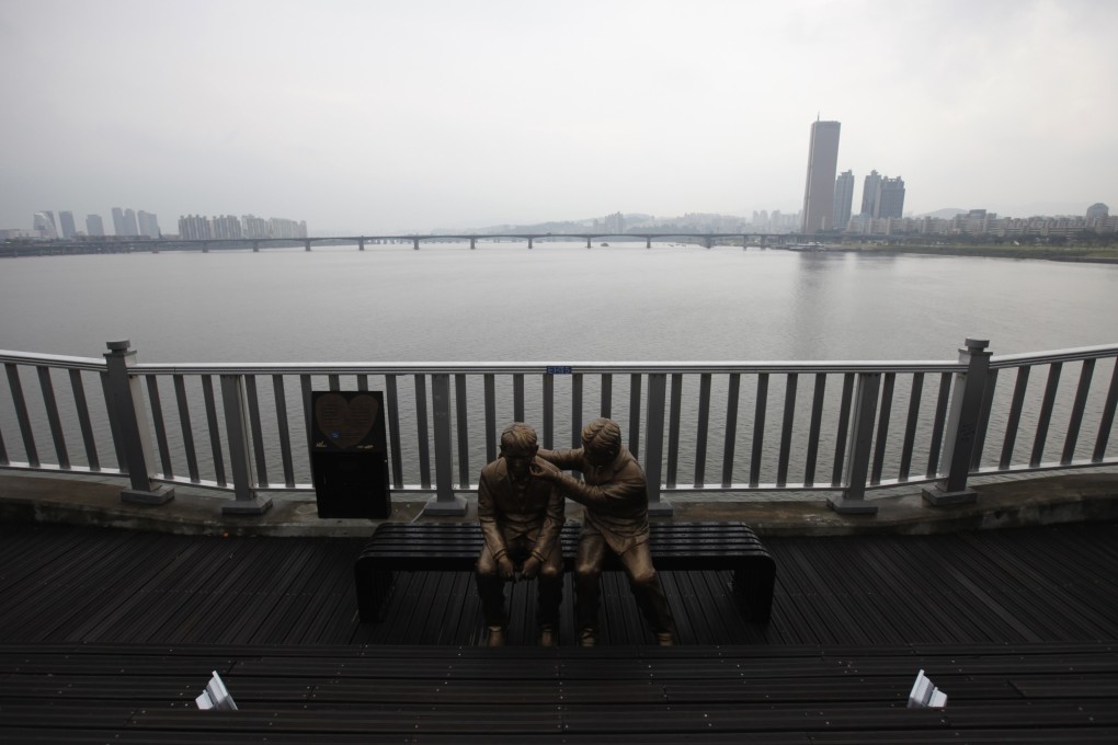 A statue of a person comforting another is set up on the Mapo Bridge in Seoul as South Korea aims to promote a message of life and hope at the bridge known as the favourite place for suicide attempts. Photo: Reuters