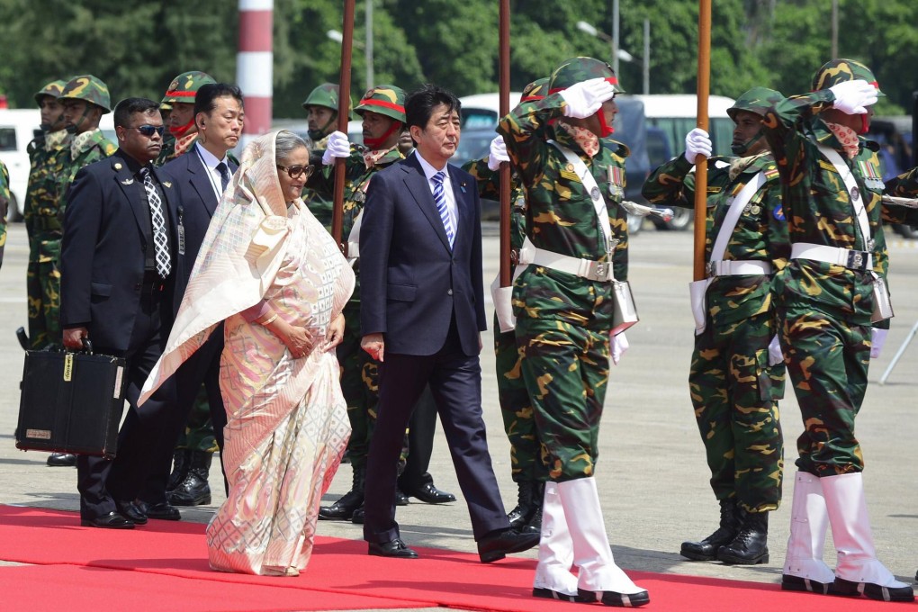 Shinzo Abe (centre) with Sheikh Hasina in Dhaka. Photo: AFP