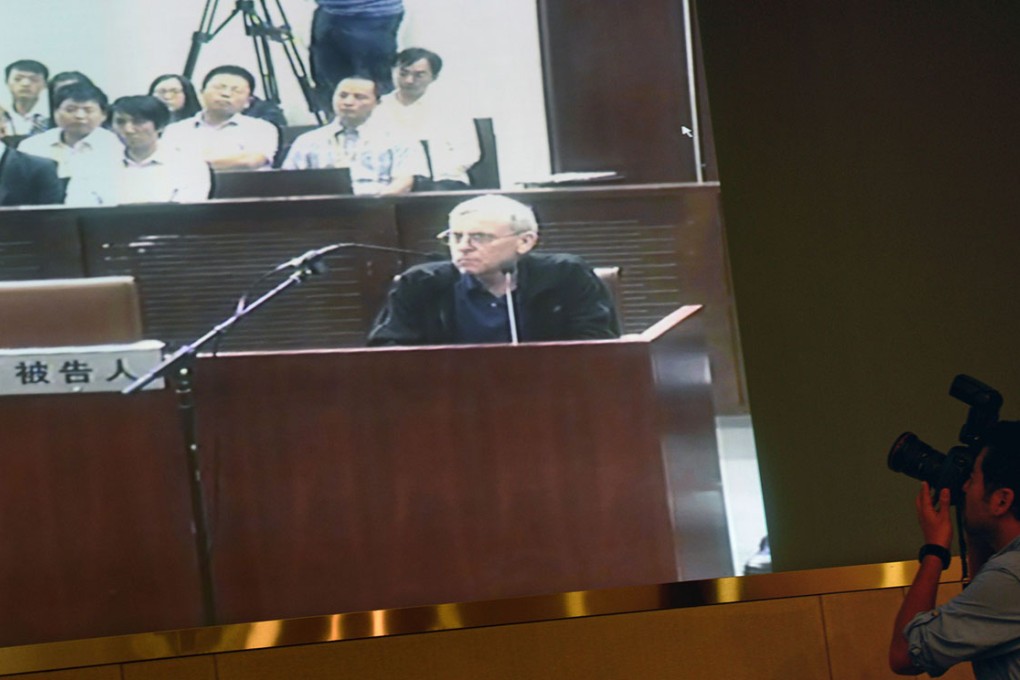 A television screen shows British investigator Peter Humphrey (centre) at his trial on charges he breached China's privacy laws. Photo: AFP