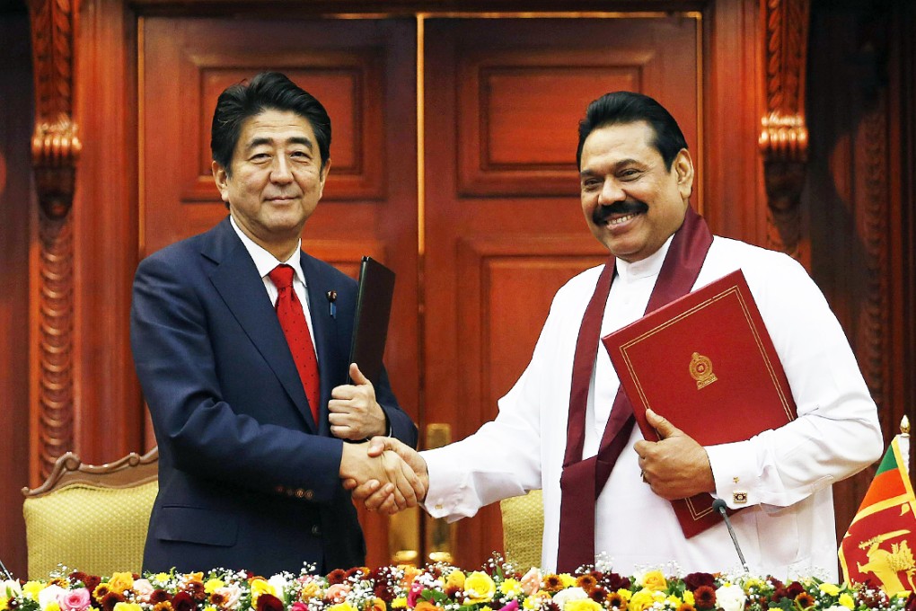 Japan's Prime Minister Shinzo Abe (left) shakes hands with Sri Lankan President Mahinda Rajapaksa. Photo: Reuters