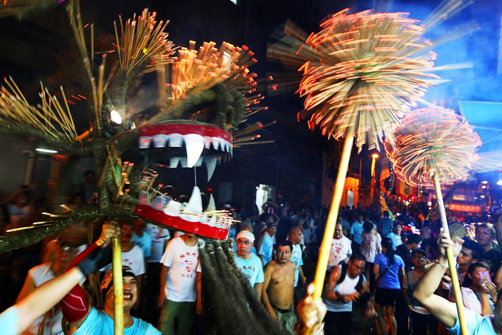 Fire dragon dancers celebrate the Mid-Autumn Festival with a performance in Tai Hang last night, following in a tradition that stretches back more than 130 years and was originally enacted by villagers to ward off plague. In 2011 the dance was included on a national list of intangible cultural heritage. Photo: Felix Wong