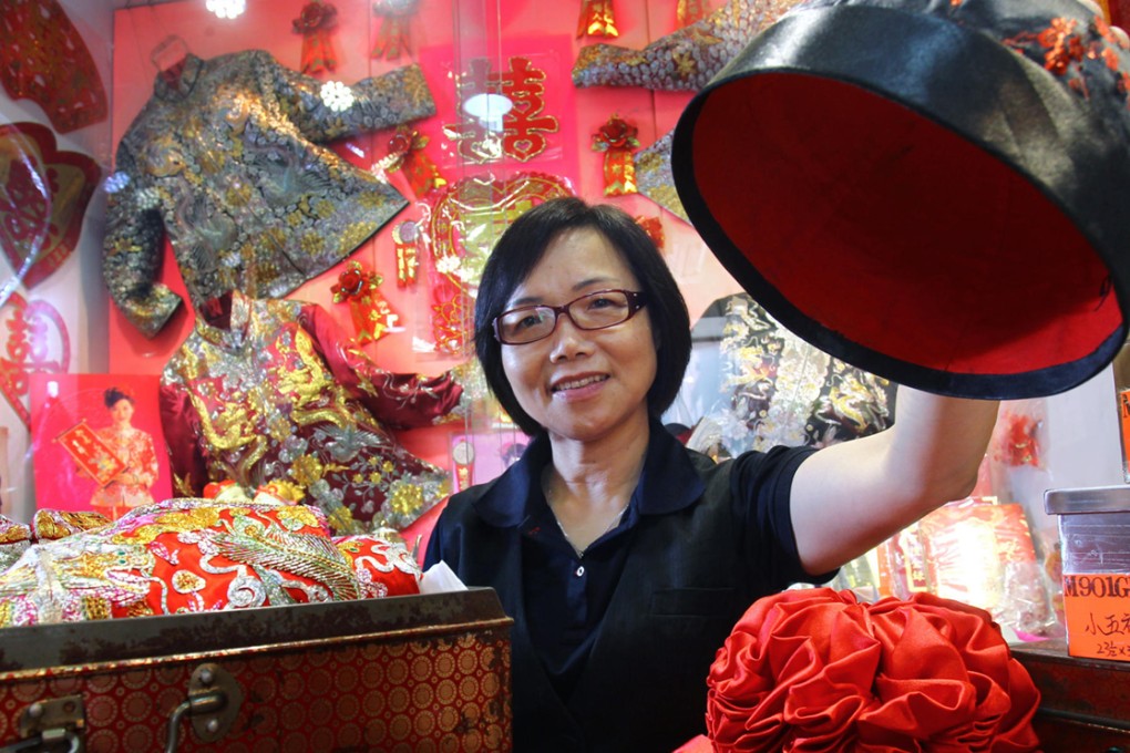 Hau Miu-ling, manager of the century-old Koon Nam Wah wedding dressmakers, is surrounded by fine silks and embroidery in the Yau Ma Tei store. Photo: May Tse