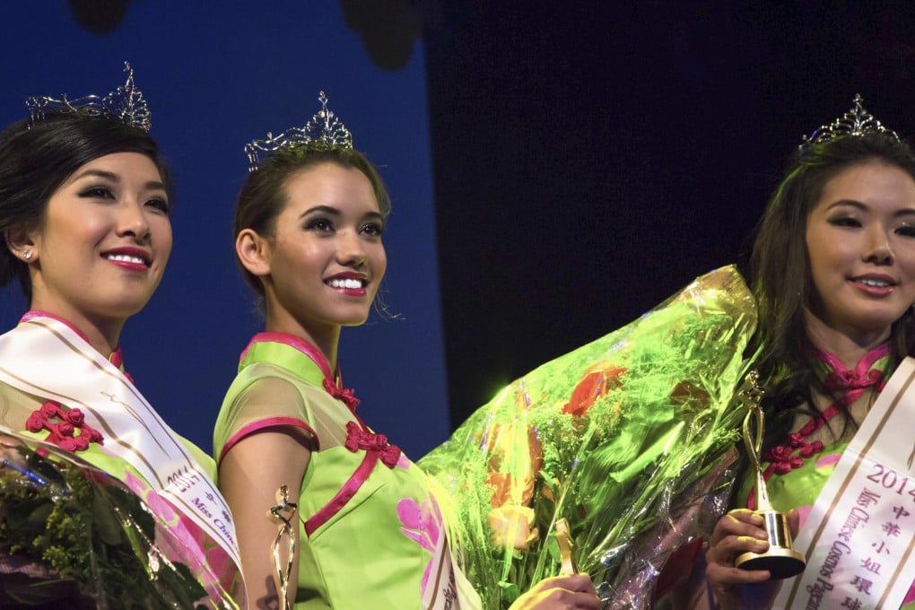 Kelly Murphy (centre), flanked by runners-up Michelle Lee (left) and Candice Hsu, is crowned South Africa's first Miss Chinese Cosmos, in Johannesburg.