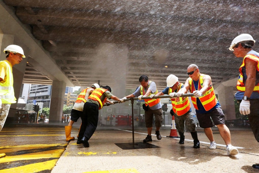 Water Supplies Department staff battle to stem a burst pipe that created a spectacular "urban geyser" in busy Causeway Bay yesterday, limiting or cutting off tap water in nearby buildings for hours. The 60cm pipe at the busy junction of Canal Road West and Leighton Road in Causeway Bay burst at about 10.30am, creating a powerful jet of water that crashed against the flyover above for more than two hours until the department brought the flow under control at 12.45pm. Photo: Sam Tsang