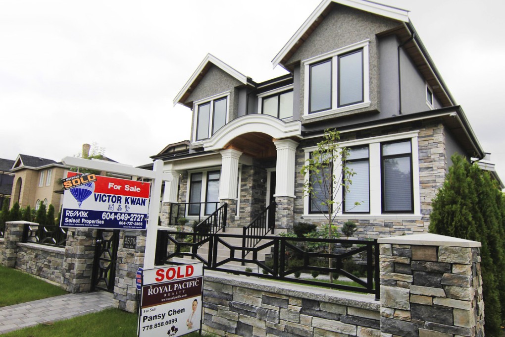 Estate agents' signs outside a newly sold property in a Vancouver neighbourhood where houses regularly sell for C$3-C$4 million. Photo: Reuters