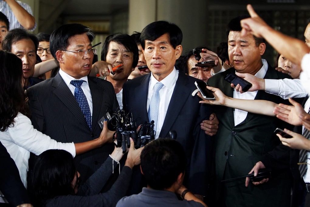 Won Sei-hoon (centre) leaves a courtroom at the Seoul Central District Court in Seoul, South Korea on September 11, 2014. Photo: EPA