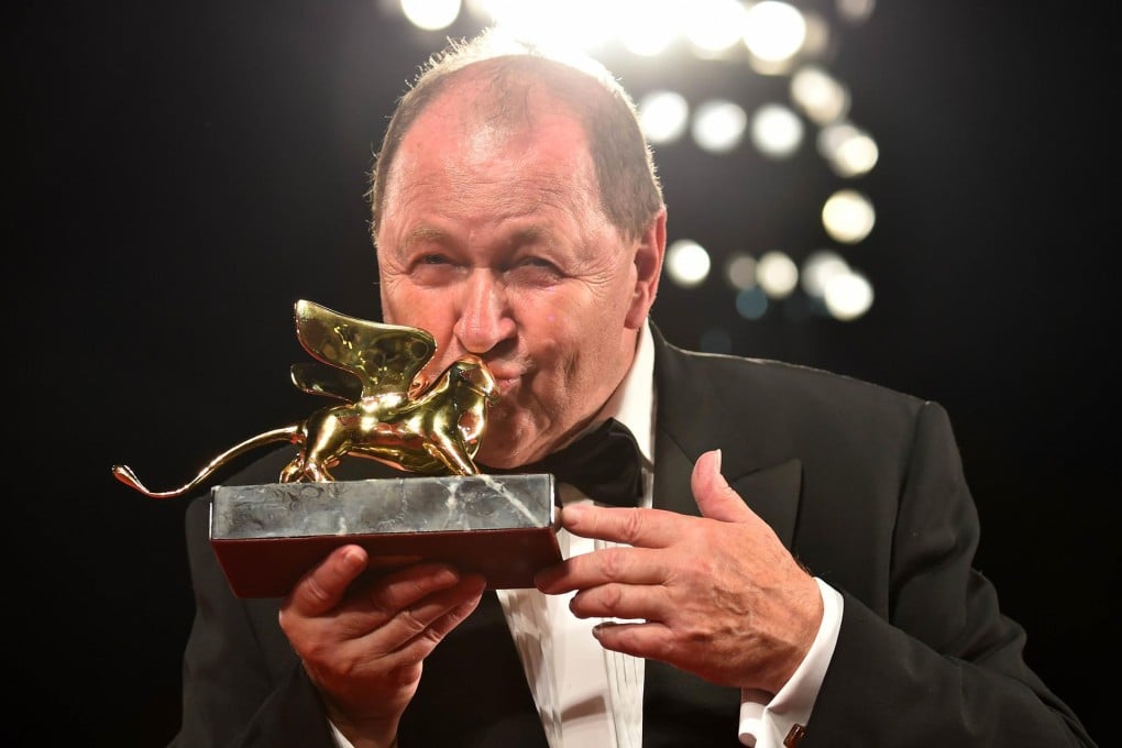 Swedish director Roy Andersson kisses the Golden Lion for best film he received for A Pigeon Sat on a Branch Reflecting on Existence. Photo: AFP