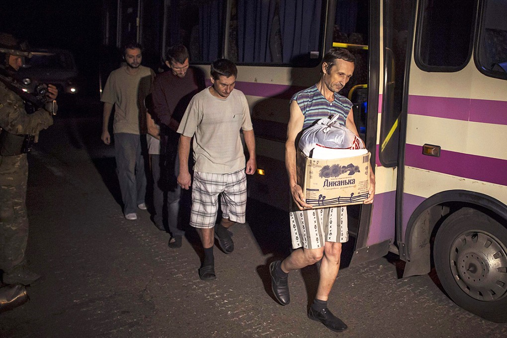 Pro-Russian rebels, who are prisoners-of-war, walk along the road as they are being exchanged, north of Donetsk in eastern Ukraine on Friday. Photo: Reuters